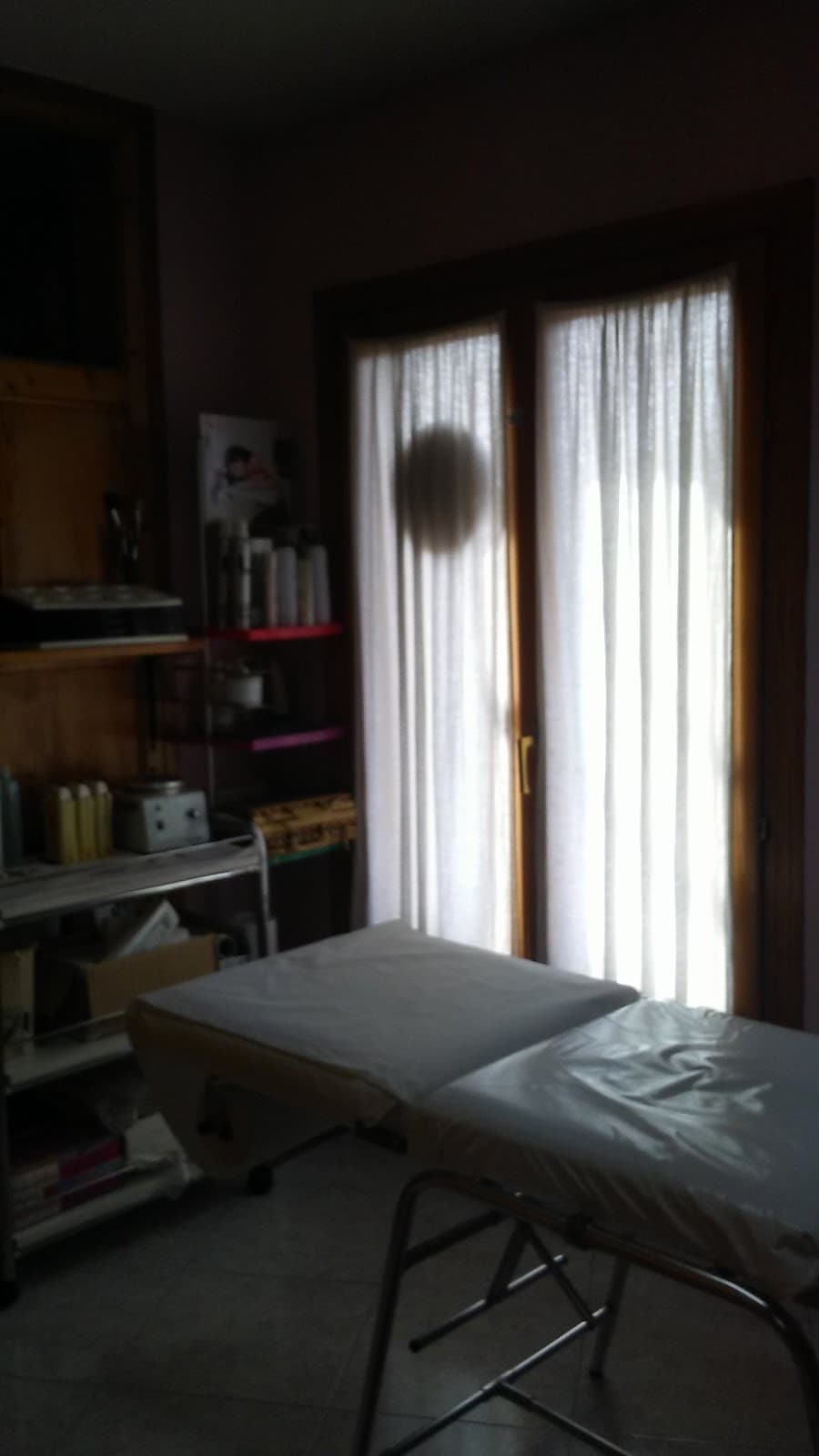 Cabina de estética con camilla junto a la ventana