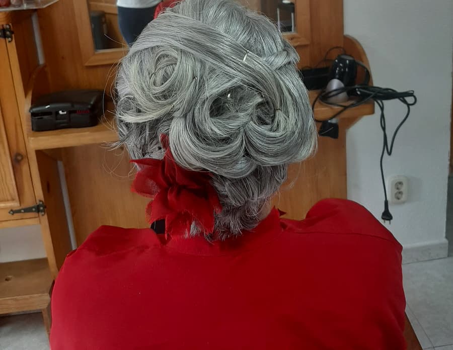 Recogido de rizos en pelo plateado con flor roja